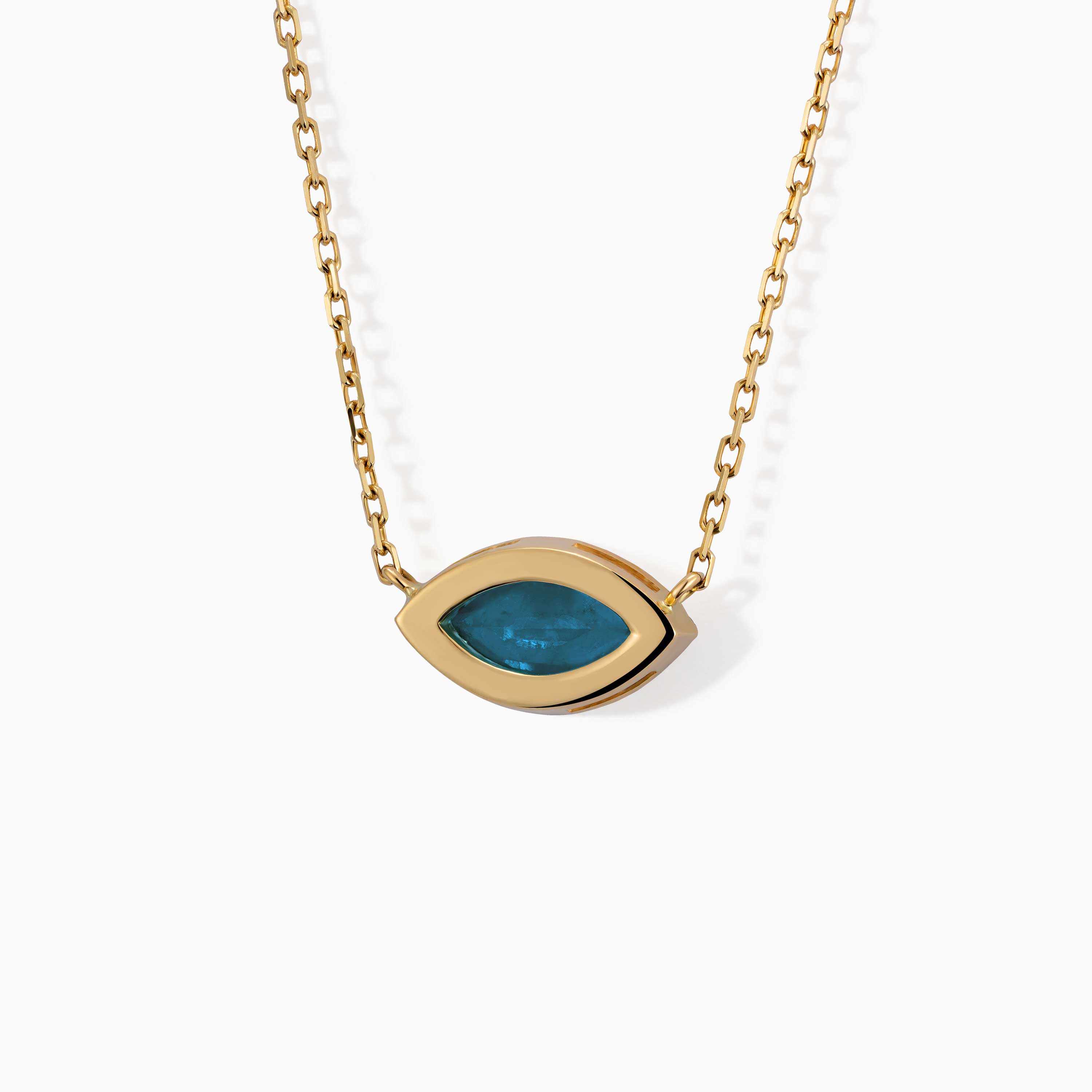 The Eye marquise necklace from Yataghan Jewellery shows a blue marquise gemstone set in a gold eye-shaped pendant on a chain.