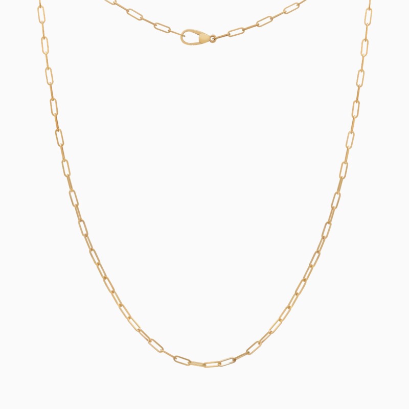 قلادة جينية بزمرد أخضر وحلية ذهبي من Yataghan Jewellery، بسلسلة روابط حلقية وبازوكة قابلة للإغلاق على خلفية بيضاء.