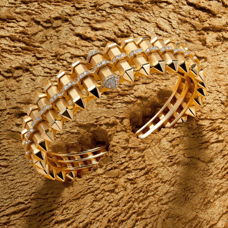 Yataghan Jewellery CHAKRA Graduated Gold Cuff in polished gold with pavé diamond details and angular spikes on a textured gold luxury backdrop.