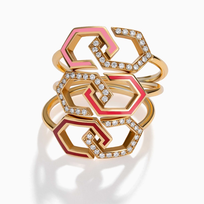 Geometric gold ring with red enamel accents and diamond pavé links forms a bold Infinity Enamel Diamond Ring Band design on a white background.