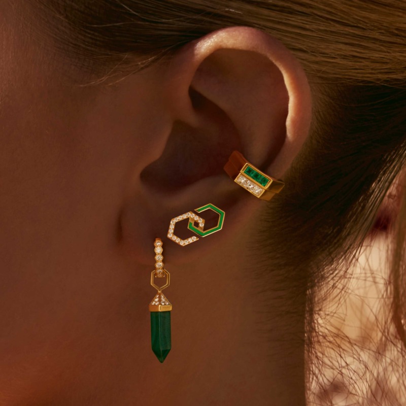 Infinity Enamel Diamond Stud Earrings in light green enamel, gold and diamonds rest on an ear, with a matching geometric dangling design below.