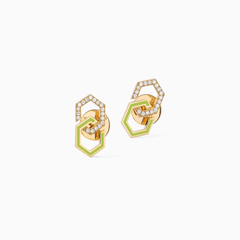 Two gold infinity stud earrings with neon green enamel and pavé-set stones rest against a clean white background, creating a refined modern jewelry look.