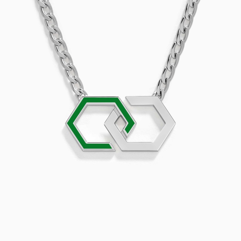 A polished silver chain holds intertwined hexagon pendants, one edged in light green enamel and one in plain metal, echoing an infinity motif.