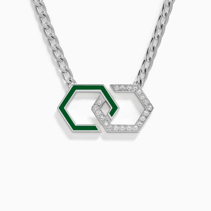 A green enamel infinity pendant with diamond accents hangs from a silver chain in a clean close-up, creating a striking modern jewellery design.
