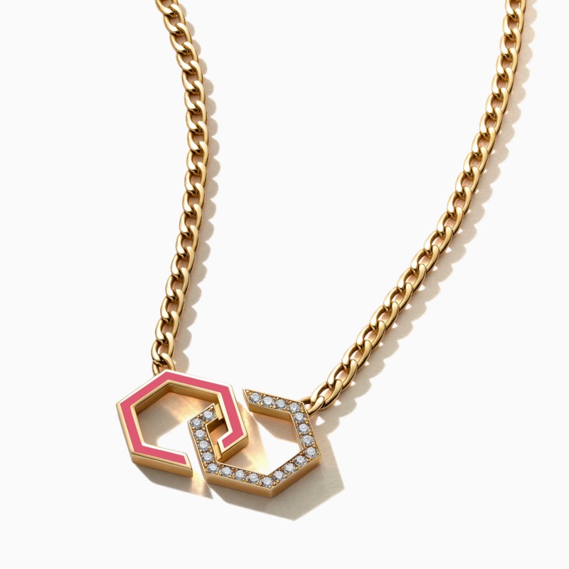 A gold chain necklace with pink enamel infinity links and diamond accents rests against a white background, creating a bright luxury jewelry look.