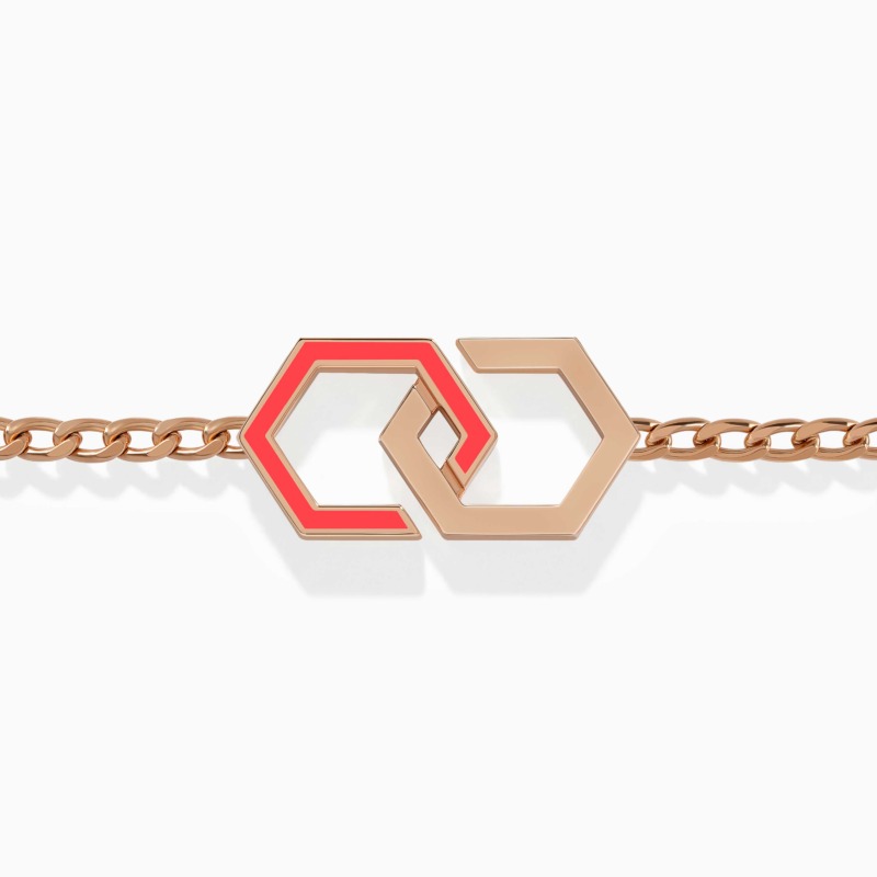 A rose gold chain bracelet with linked hexagon motifs and bright pink enamel stands out against a white background, with polished metallic shine.