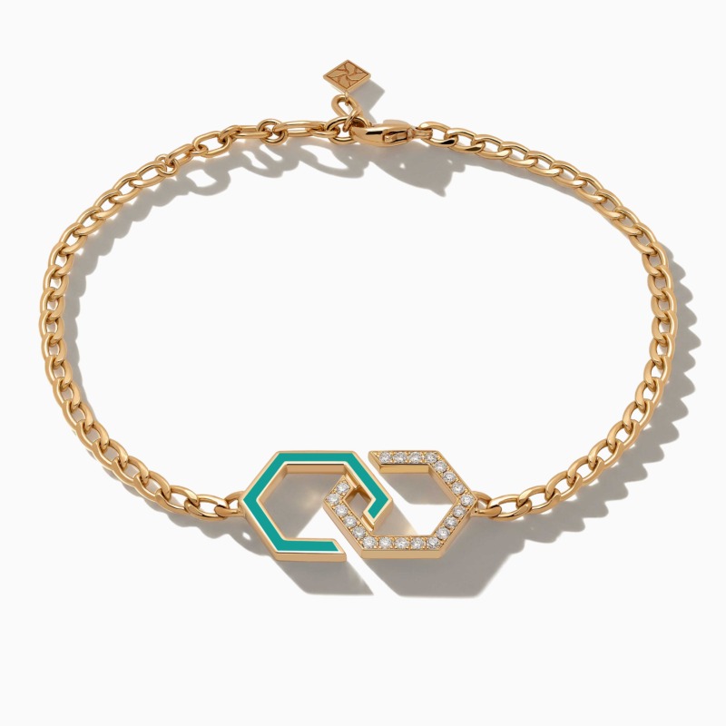 A gold chain bracelet with turquoise enamel infinity links and diamond accents rests on a white background, reflecting the Infinity collection.