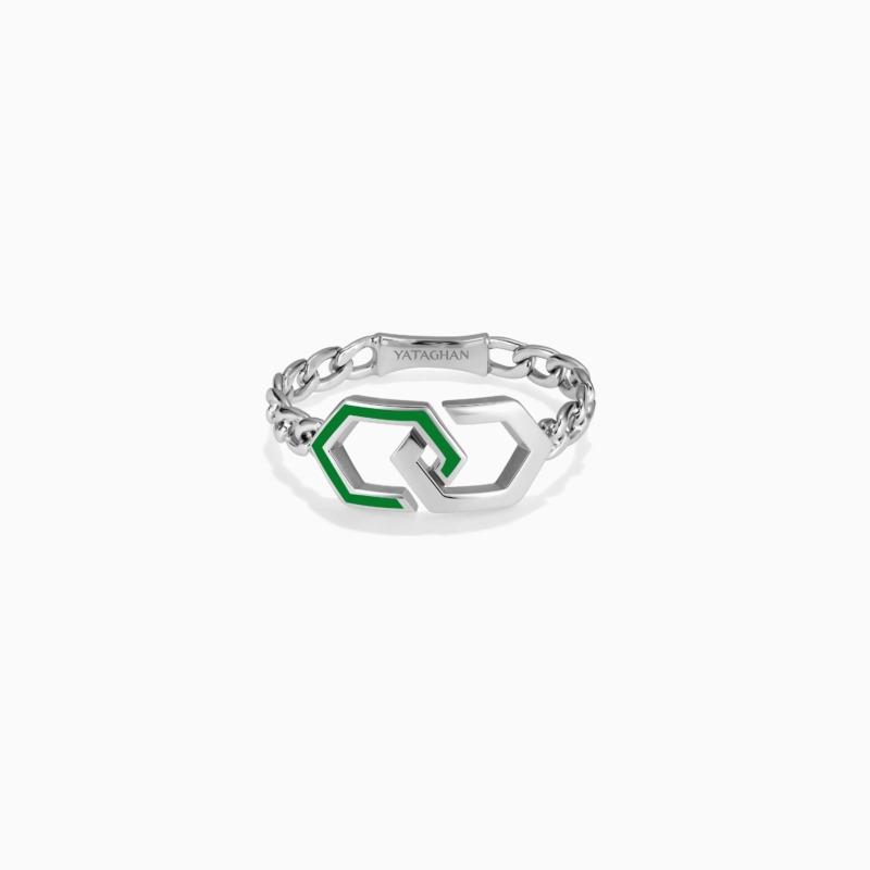 A silver infinity ring with light green enamel accents and linked chain details sits on a white background, with YATAGHAN engraved across the top.