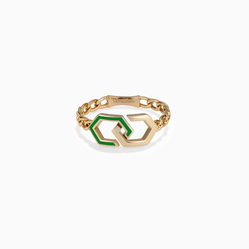 A gold chain ring with interlocking infinity links and green enamel accents rests on a white background, with YATAGHAN engraved on the clasp.