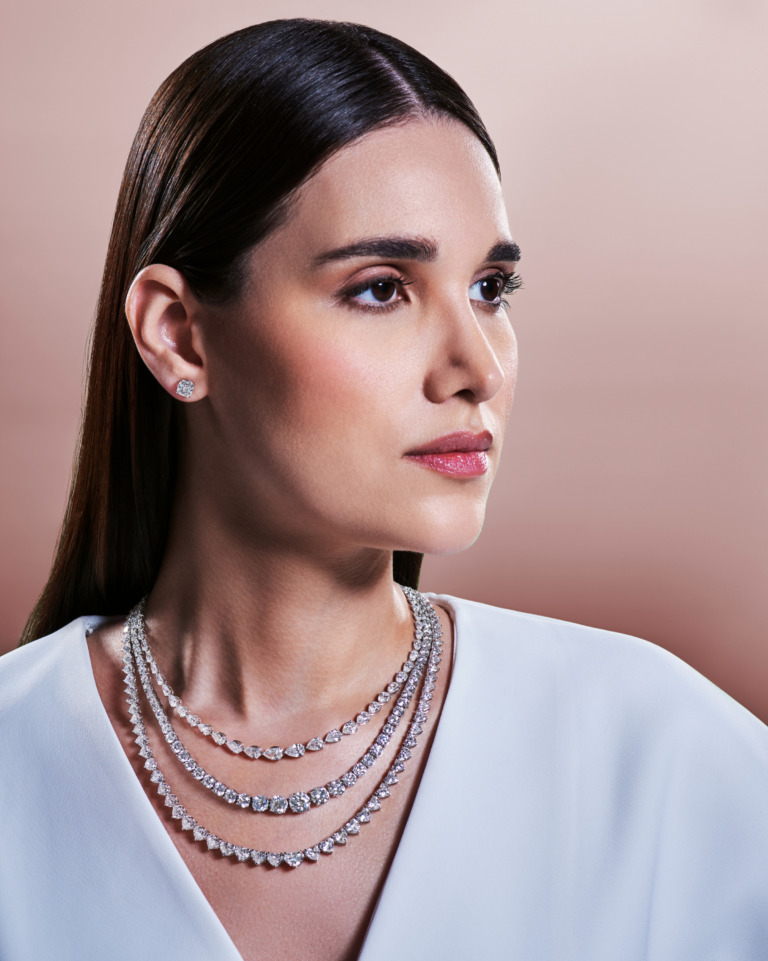 A model wears layered diamond necklaces and stud earrings from Yataghan High Jewellery, reflecting the timeless creations with a touch of modern flame.