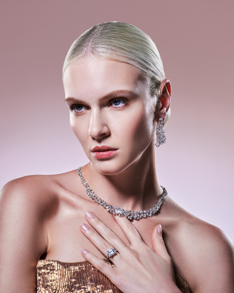 A blonde model presents Yataghan High Jewellery with a diamond necklace, drop earrings and a large ring, reflecting the maison's timeless elegance.