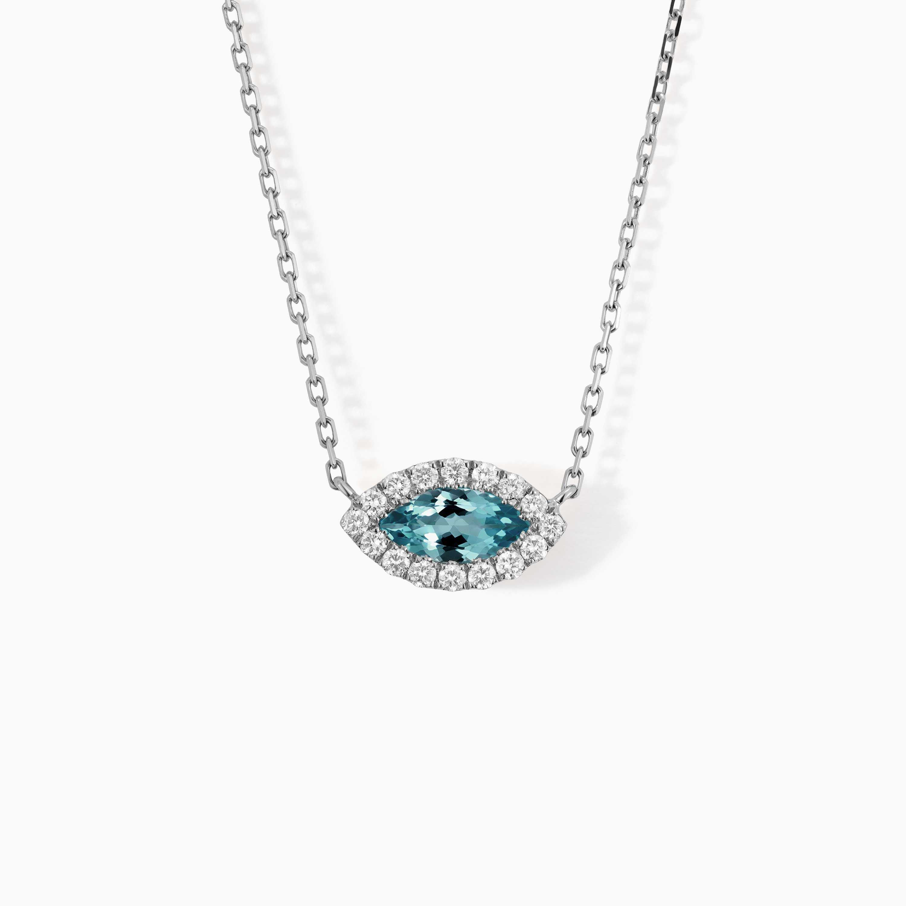 A marquise blue topaz pendant with a diamond halo hangs from a white gold chain, with Yataghan Jewellery styling.