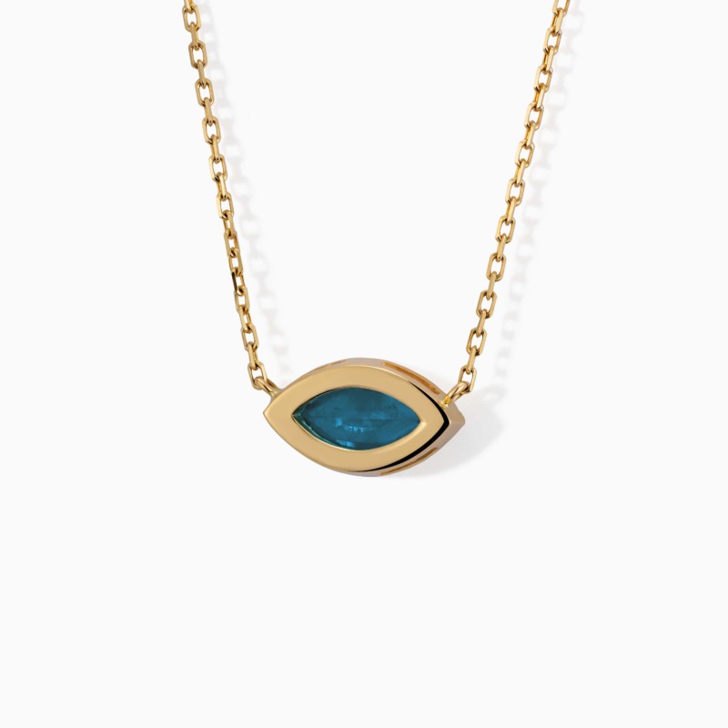A gold chain necklace centers on a marquise-shaped blue gemstone framed by a polished eye motif.