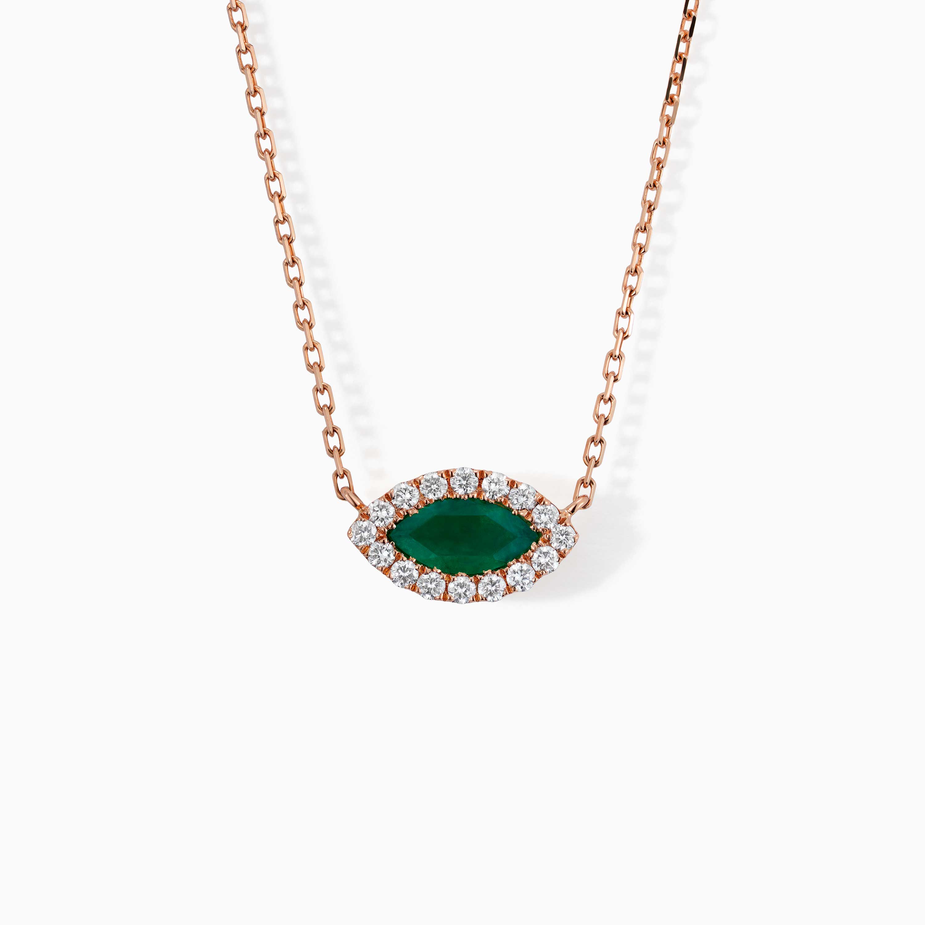 A rose gold necklace with a marquise emerald center stone surrounded by diamonds hangs against a white background.