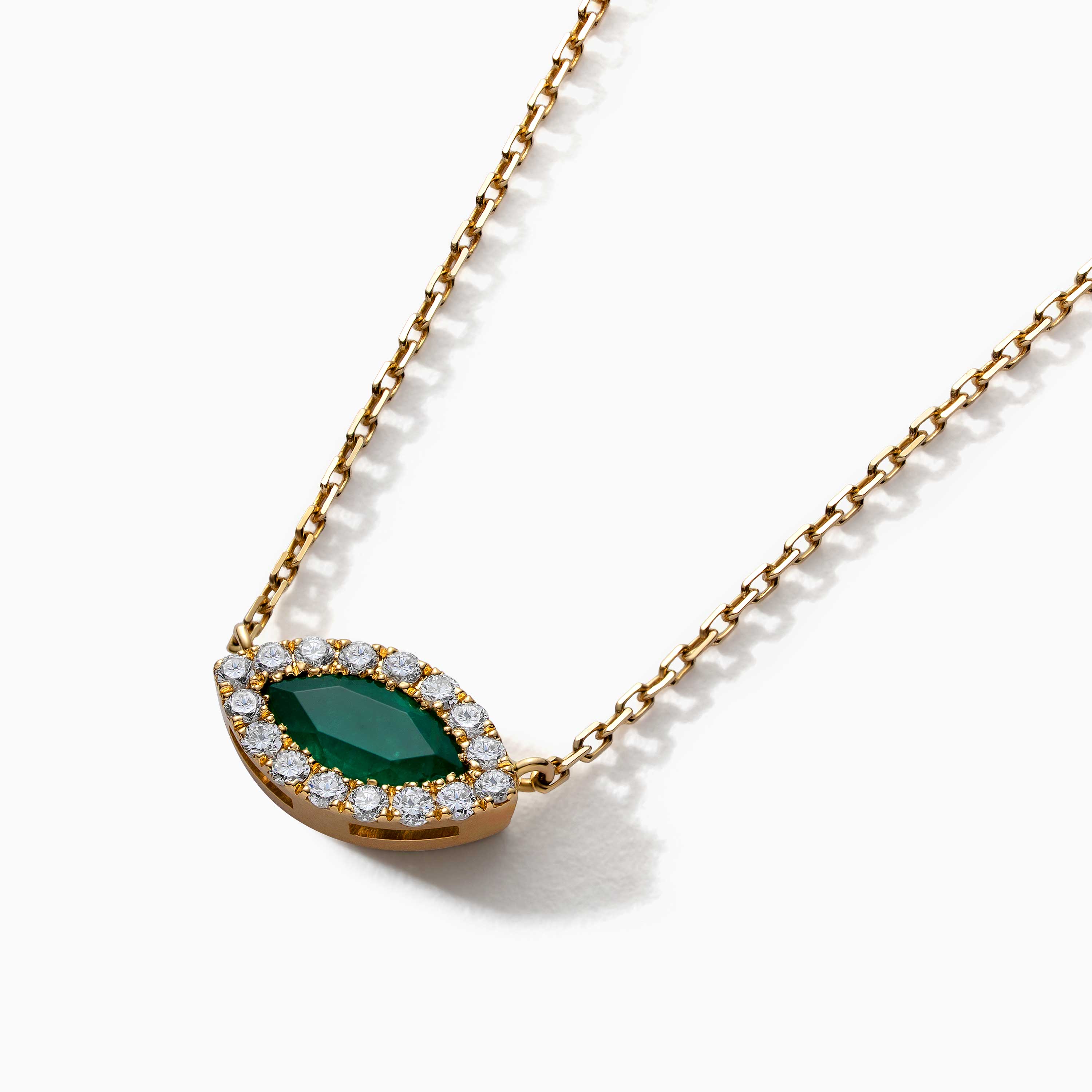 Gold necklace with a marquise-cut emerald pendant framed by diamonds on a clean white background.