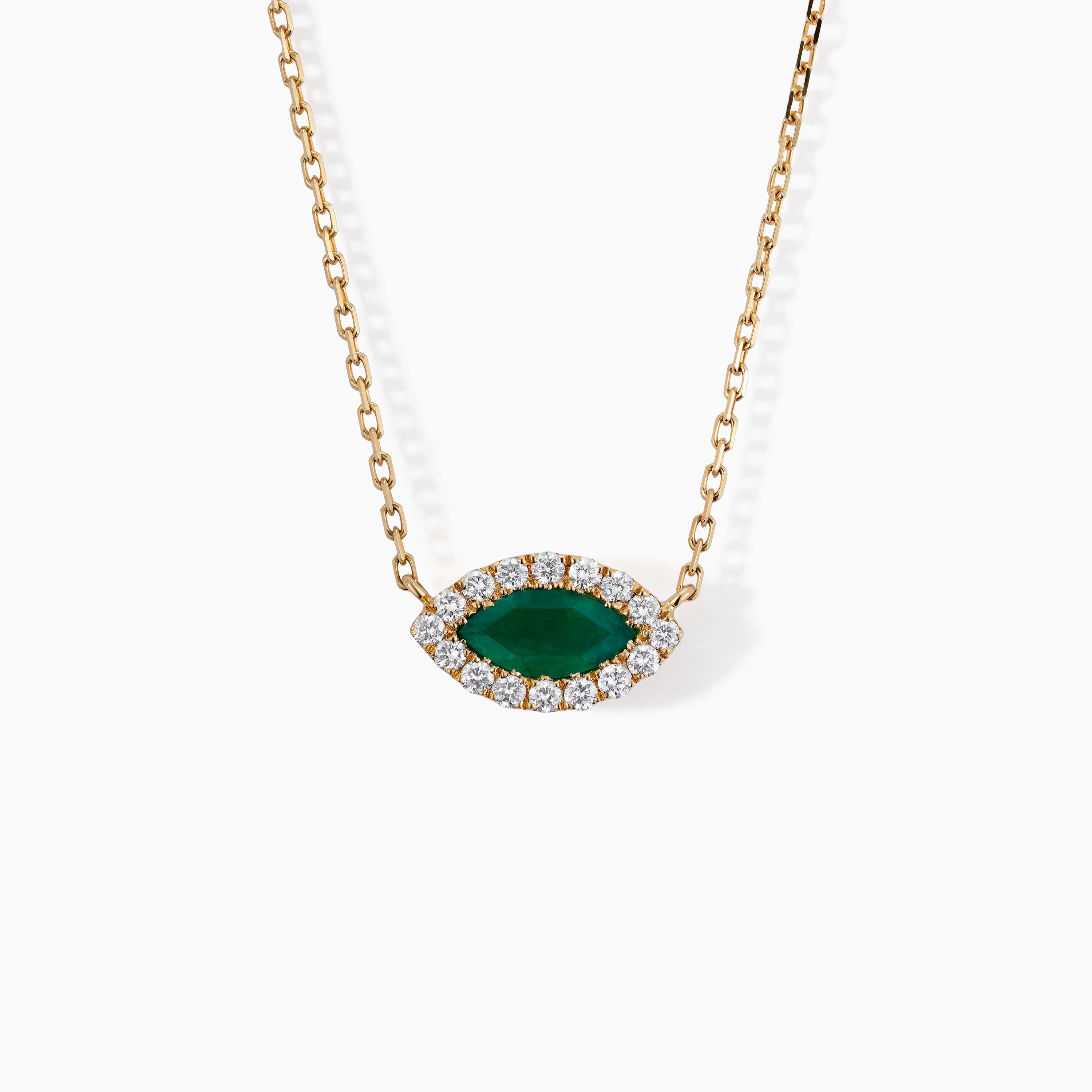 A gold chain necklace with a marquise green emerald center stone surrounded by diamonds on a white background.